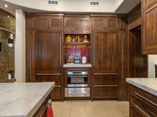 Experience luxury in this stunning kitchen featuring custom dark wood cabinetry that exudes warmth and sophistication.