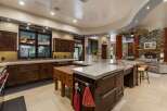 Experience luxury living in this stunning kitchen featuring rich dark wood cabinetry and expansive marble countertops.