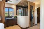 Experience luxury in this master bathroom featuring a stunning curved glass shower with intricate mosaic tile accents.