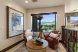 Experience breathtaking mountain views from this cozy reading nook, featuring two plush leather armchairs and a unique rope-wrapped coffee table.