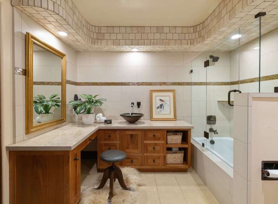This luxurious bathroom features a spacious vanity with ample storage and a decorative mosaic tile backsplash.