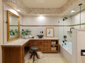 This luxurious bathroom features a spacious vanity with ample storage and a decorative mosaic tile backsplash.