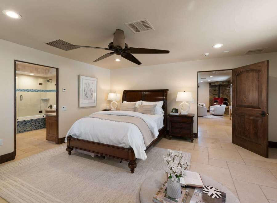 Experience luxurious comfort in this master suite, featuring a spacious king-sized bed adorned with crisp white linens and plush pillows.