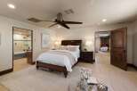 Experience luxurious comfort in this master suite, featuring a spacious king-sized bed adorned with crisp white linens and plush pillows.