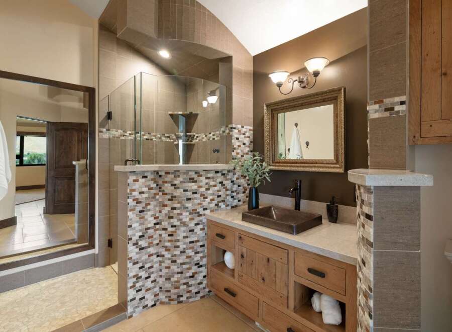 Experience luxury in this master bathroom featuring a spacious walk-in shower with elegant tile accents and a modern vanity with ample storage.