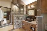 Experience luxury in this master bathroom featuring a spacious walk-in shower with elegant tile accents and a modern vanity with ample storage.