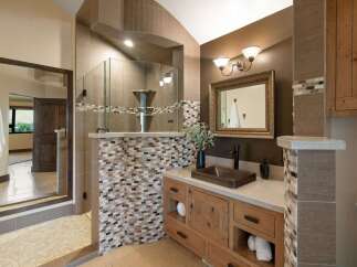 Experience luxury in this master bathroom featuring a spacious walk-in shower with elegant tile accents and a modern vanity with ample storage.