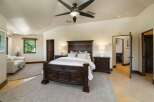 Experience luxury in this spacious master suite, featuring a grand dark wood bed as the centerpiece and elegant white lamps on matching nightstands.