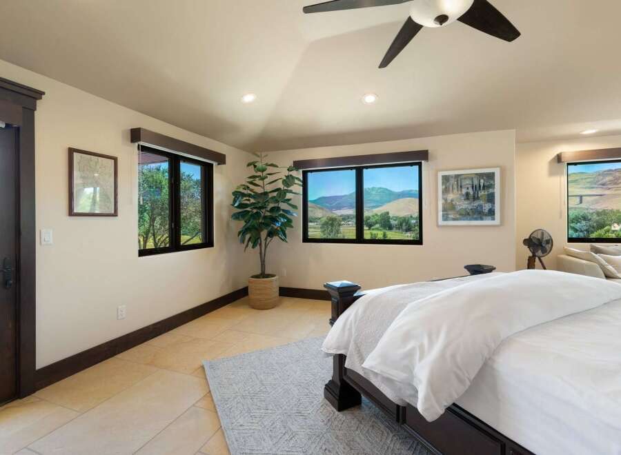 Experience breathtaking mountain views from this stunning bedroom, featuring expansive windows that bring the outdoors in.