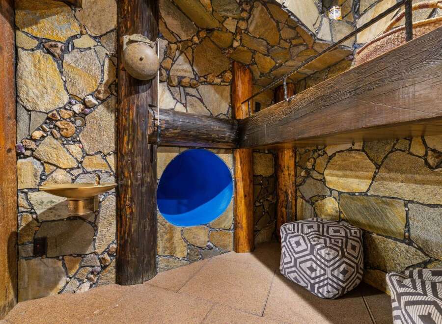 Discover a unique architectural gem featuring rustic stone walls and exposed wooden beams, creating a warm and inviting atmosphere.