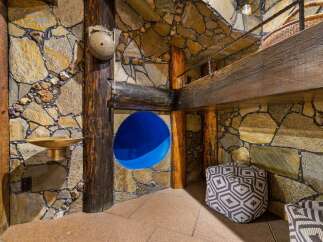 Discover a unique architectural gem featuring rustic stone walls and exposed wooden beams, creating a warm and inviting atmosphere.
