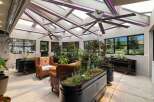 Experience year-round gardening in this stunning sunroom, featuring a retractable roof and integrated grow lights for optimal plant growth.