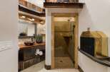 Experience rustic charm in this unique bathroom featuring a live-edge wood vanity with a vessel sink and a spacious walk-in shower with stone tile accents.