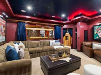 Step into a cinematic paradise with this custom home theater, featuring plush seating and immersive ambiance.