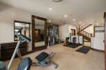 This home gym features a variety of weight training equipment, including a multi-station weight machine and adjustable benches.