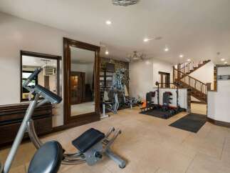 This home gym features a variety of weight training equipment, including a multi-station weight machine and adjustable benches.