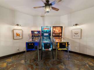 Step into a world of retro fun with this game room featuring three classic pinball machines: Jaws, Indiana Jones, and another themed machine.