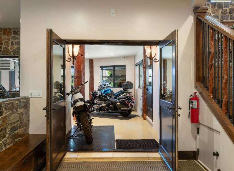 This unique property offers a spacious garage area perfect for motorcycle enthusiasts, featuring two distinct bikes ready for adventure.