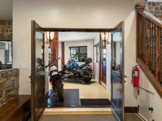 This unique property offers a spacious garage area perfect for motorcycle enthusiasts, featuring two distinct bikes ready for adventure.