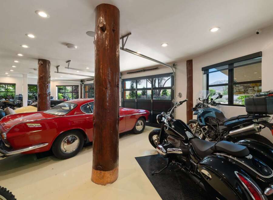 This spacious garage offers ample storage for multiple vehicles, including classic cars and motorcycles.