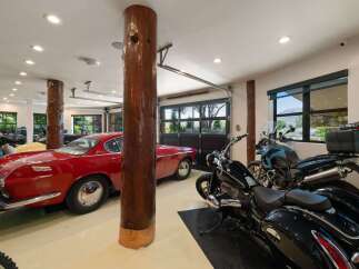 This spacious garage offers ample storage for multiple vehicles, including classic cars and motorcycles.