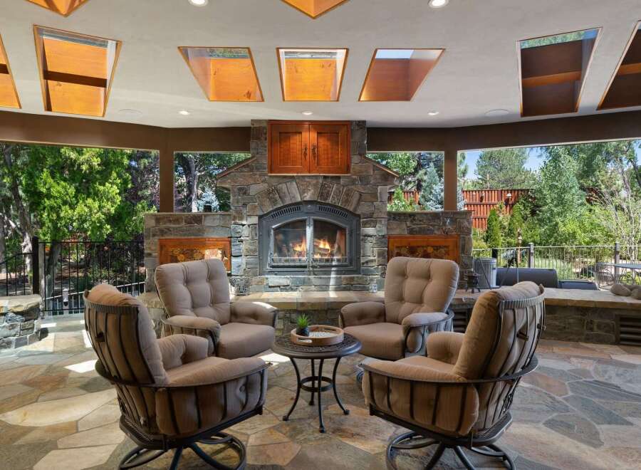 Experience ultimate outdoor living with this stunning patio featuring a grand stone fireplace, perfect for cozy evenings.