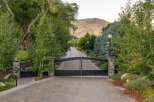 Welcome to this stunning estate, accessed through grand black iron gates and a paved driveway lined with mature trees and elegant lampposts.