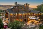 Experience luxury living in this stunning multi-story home, featuring a spacious outdoor entertainment area with a built-in grill and seating.