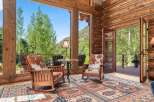 Experience rustic charm in this log cabin living area, featuring cozy rocking chairs with cowhide cushions and a large area rug.