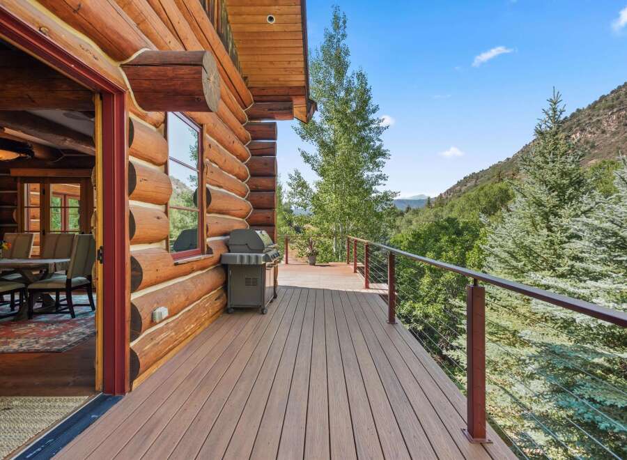 Experience rustic charm and modern comfort on this expansive log cabin deck, perfect for outdoor entertaining.