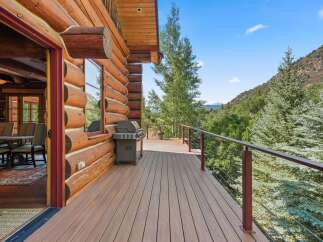 Experience rustic charm and modern comfort on this expansive log cabin deck, perfect for outdoor entertaining.