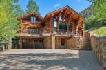 Experience rustic luxury in this stunning log home, nestled against a scenic mountainside.