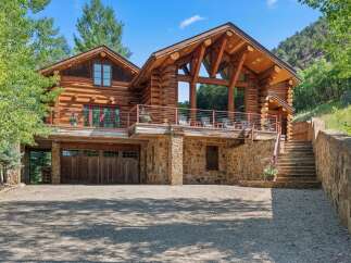 Experience rustic luxury in this stunning log home, nestled against a scenic mountainside.