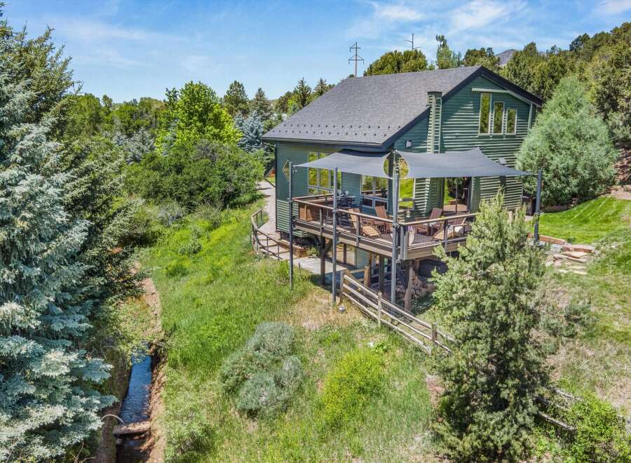 Experience the perfect blend of nature and modern living in this stunning green home, nestled amidst lush trees and a serene stream.