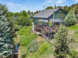 Experience the perfect blend of nature and modern living in this stunning green home, nestled amidst lush trees and a serene stream.