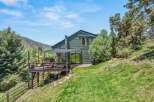 Experience stunning mountain views from this contemporary green home, featuring a spacious multi-level deck perfect for entertaining.