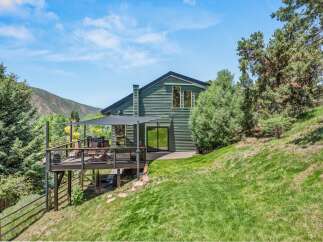 Experience stunning mountain views from this contemporary green home, featuring a spacious multi-level deck perfect for entertaining.