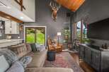 Experience rustic charm in this inviting living room, featuring a cozy sectional sofa and a striking mounted deer head.