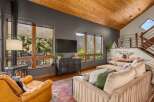 Experience breathtaking mountain views from this stunning living room, featuring a cozy fireplace and a large sectional sofa perfect for relaxation.