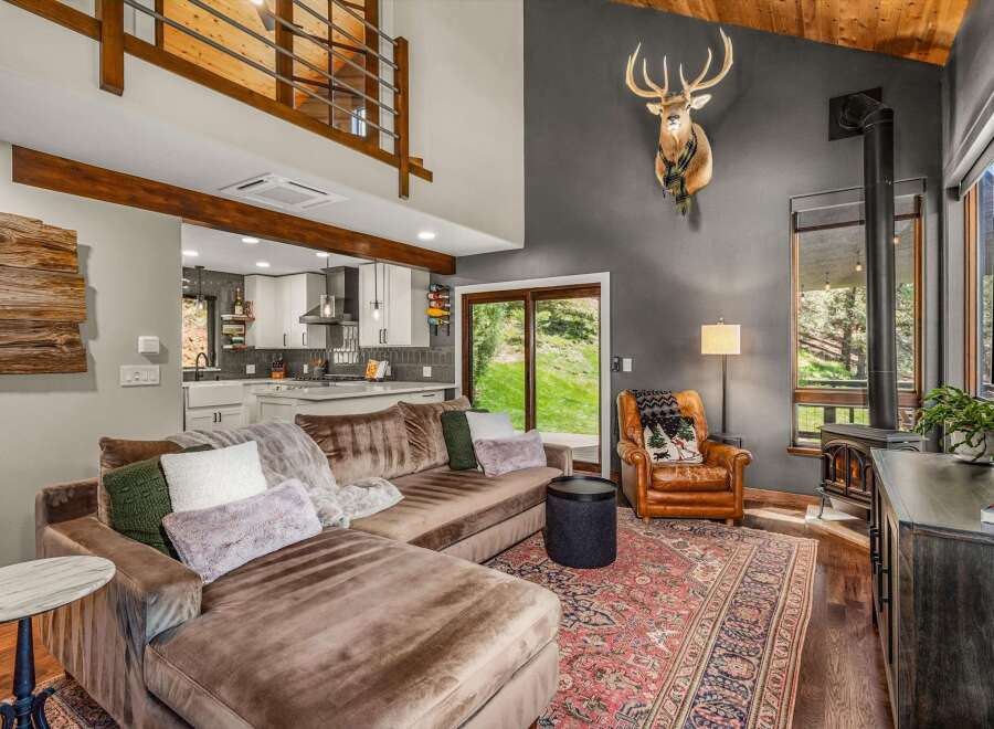 Experience rustic charm in this mountain-inspired living room, featuring a plush sectional sofa and a cozy leather armchair.
