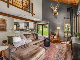 Experience rustic charm in this mountain-inspired living room, featuring a plush sectional sofa and a cozy leather armchair.