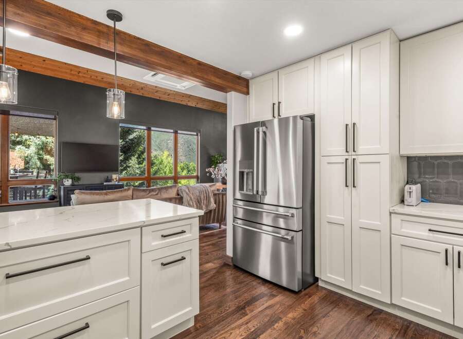 Experience modern living in this stunning kitchen featuring sleek white cabinetry and a spacious island with a quartz countertop.
