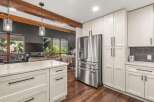 Experience modern living in this stunning kitchen featuring sleek white cabinetry and a spacious island with a quartz countertop.