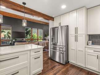 Experience modern living in this stunning kitchen featuring sleek white cabinetry and a spacious island with a quartz countertop.
