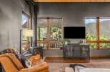 Experience cozy living in this mountain retreat, featuring a rustic wood-burning stove and a plush leather armchair perfect for relaxing evenings.