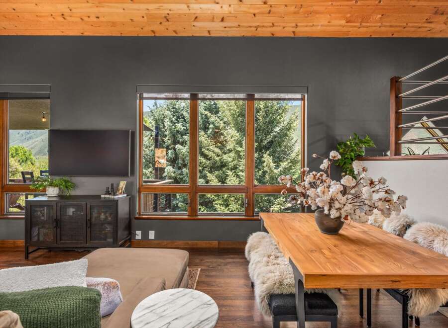 Experience breathtaking mountain views from this stunning living and dining area, featuring a large picture window that frames the lush greenery.