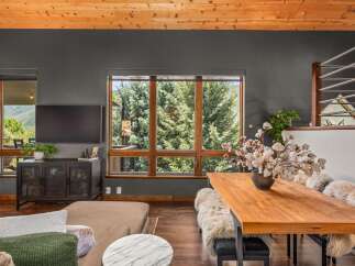 Experience breathtaking mountain views from this stunning living and dining area, featuring a large picture window that frames the lush greenery.