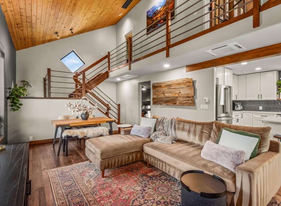Experience modern mountain living in this stunning home featuring a vaulted wood-paneled ceiling and a dramatic open-concept living space.
