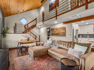 Experience modern mountain living in this stunning home featuring a vaulted wood-paneled ceiling and a dramatic open-concept living space.