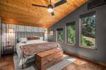 Experience rustic charm in this inviting bedroom, featuring a vaulted wood-paneled ceiling and a cozy atmosphere.